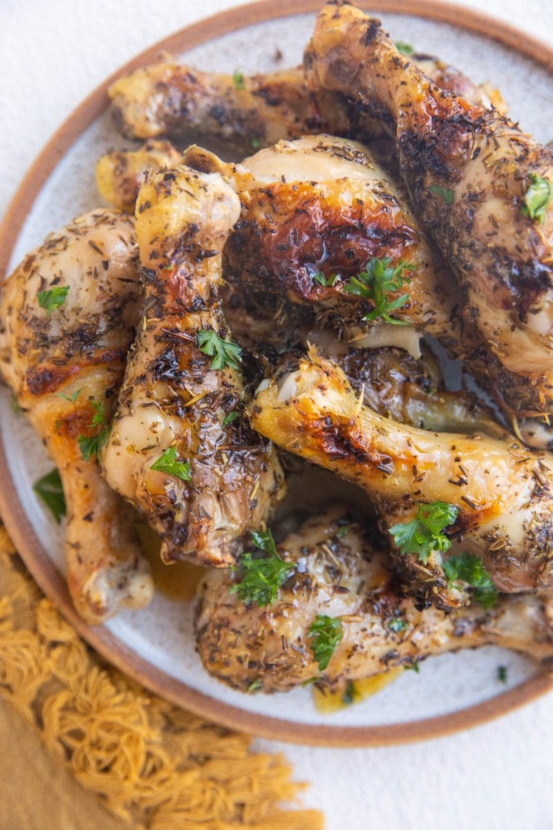 Top down plate of drumsticks with a golden napkin to the side.