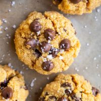 Close up top down photo of pumpkin chocolate chip cookies on a baking sheet