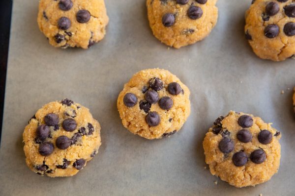 Raw cookie dough for pumpkin cookies on a baking sheet