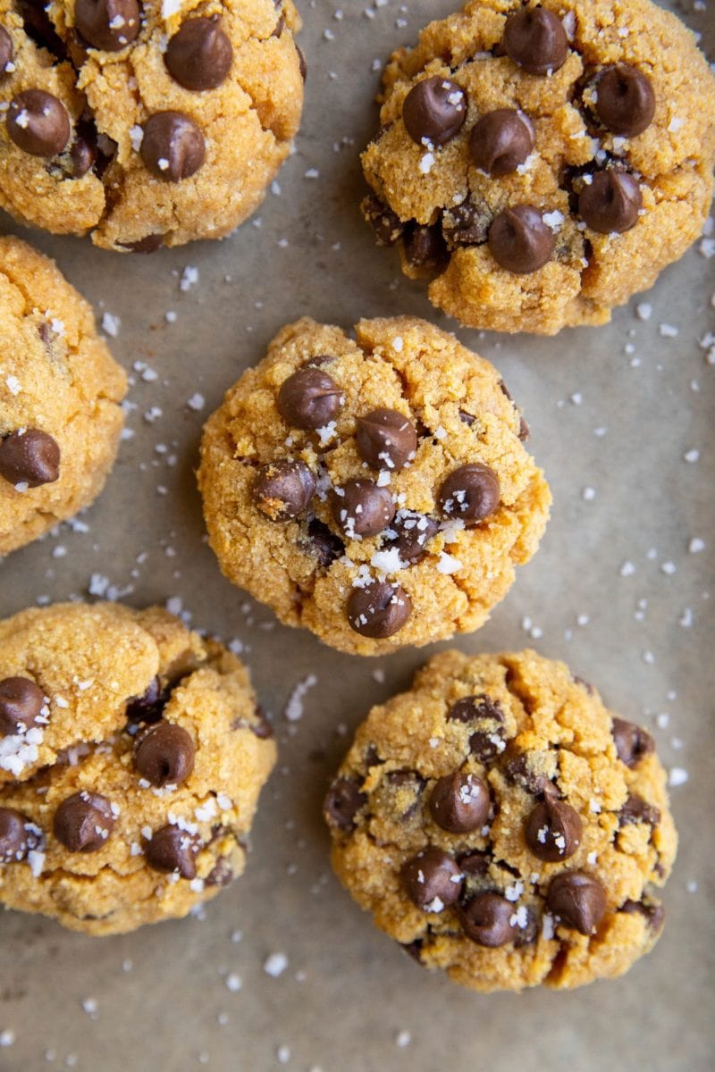 Sugar free pumpkin chocolate chip cookies on a baking sheet with flaky sea salt on top