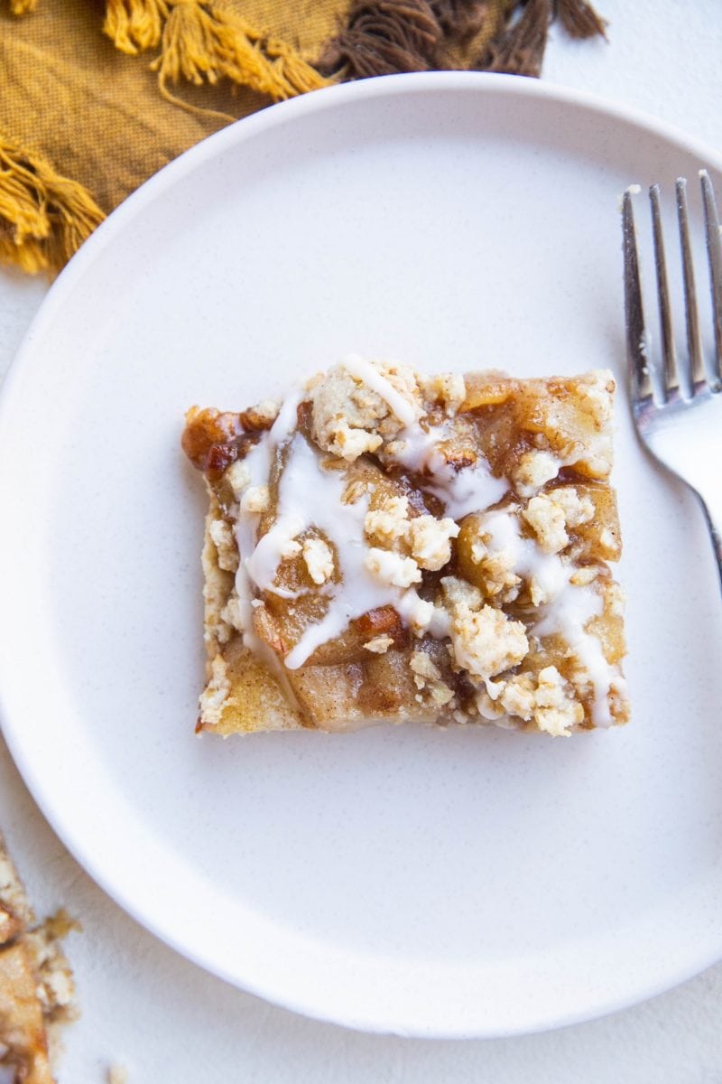 Slice of pear bar on a plate with a napkin to the side.