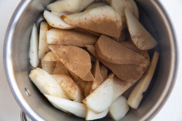 Pears, cinnamon and pure maple syrup in a saucepan, ready to be heated up