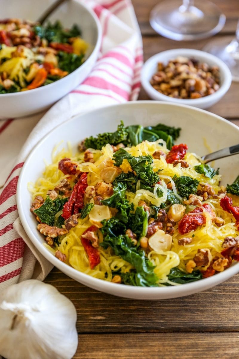 Two bowls of spaghetti squash with roasted garlic, kale, and sun-dried tomatoes