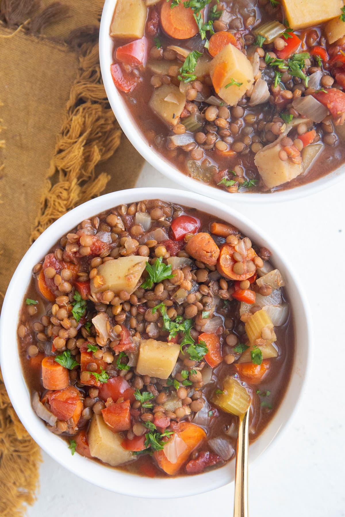 Top down photo of two white bowls of lentil soup.