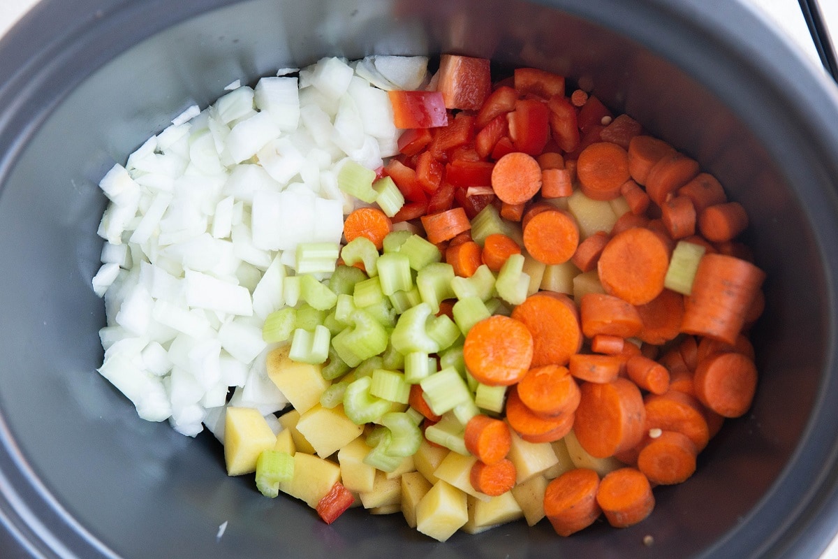 Vegetables in a crock pot for lentil stew.