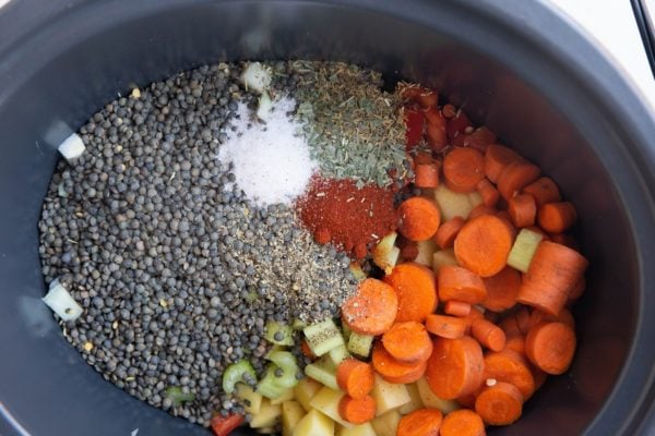 Vegetables, lentils, and seasonings in a crock pot.
