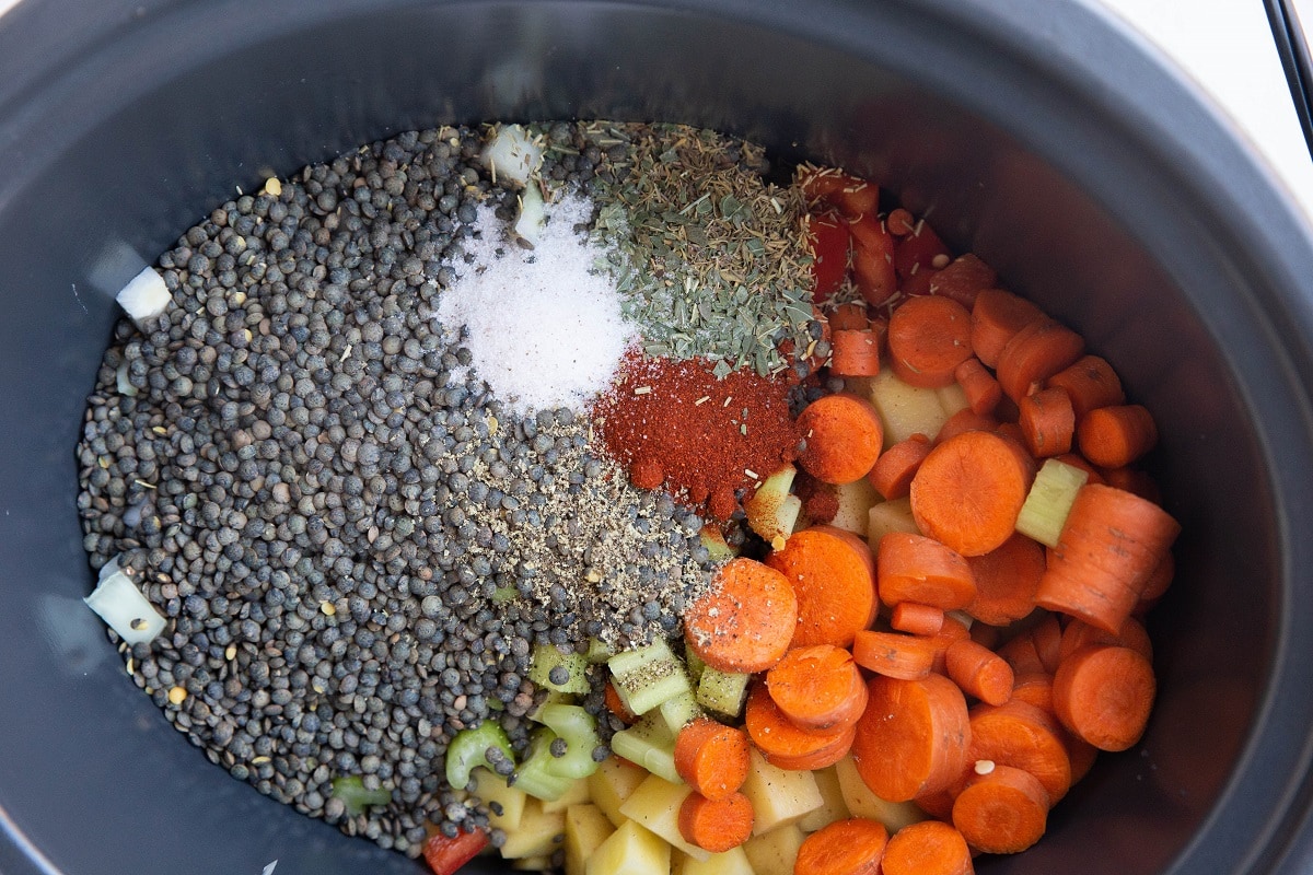 Vegetables, lentils, and seasonings in a crock pot.