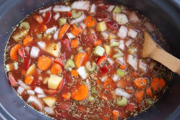 Stirred up ingredients for lentil soup in a crock pot, ready to cook.