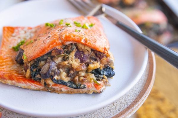 Horizontal image of a stuffed salmon filet on a plate.