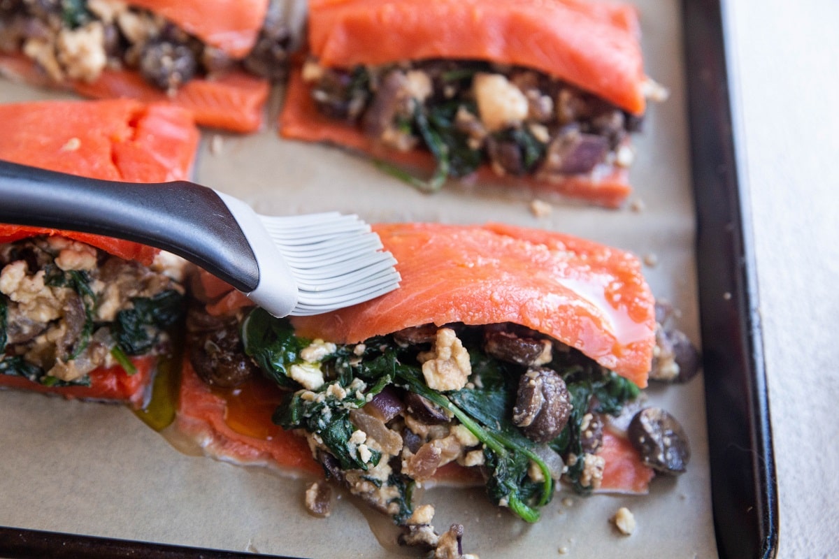 Silicone brush brushing the salmon with avocado oil.