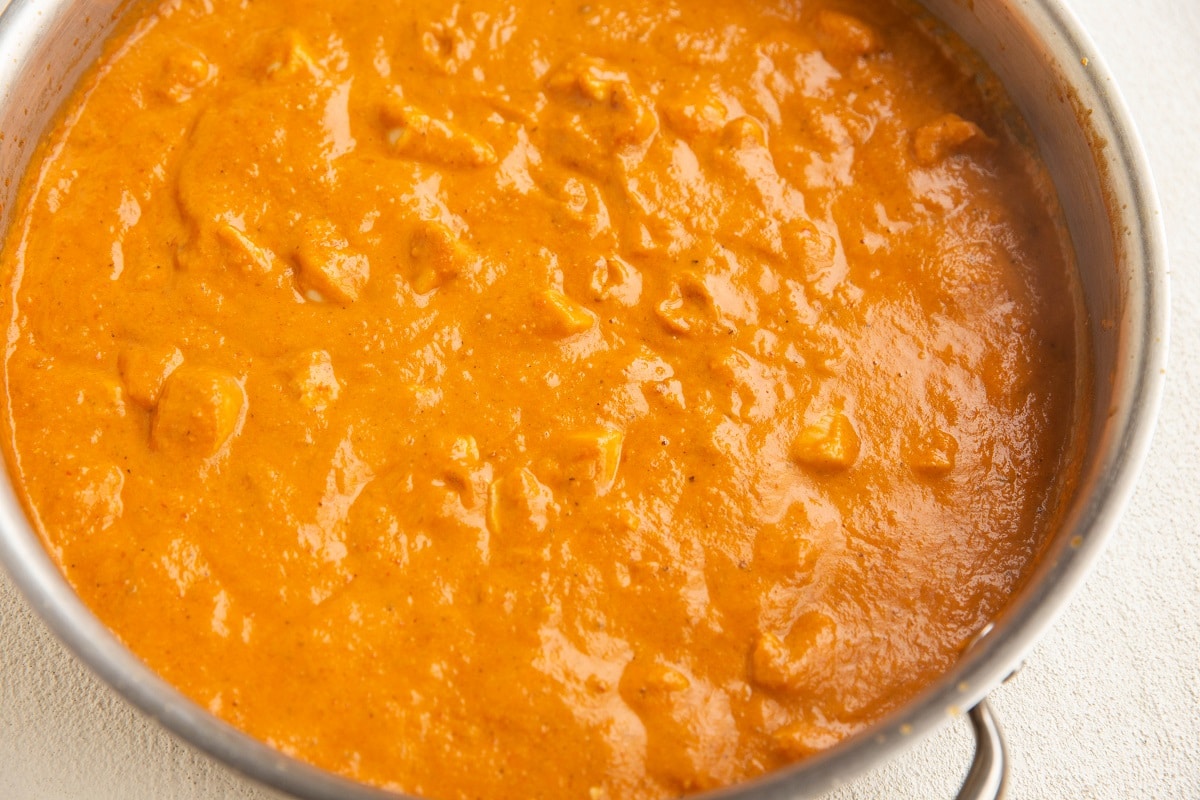 Chicken and sun-dried tomato pasta sauce in a skillet.