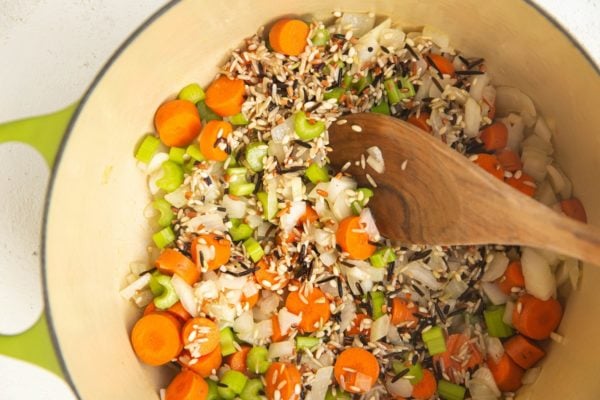 Carrots, onion, celery, garlic and wild rice in a soup pot