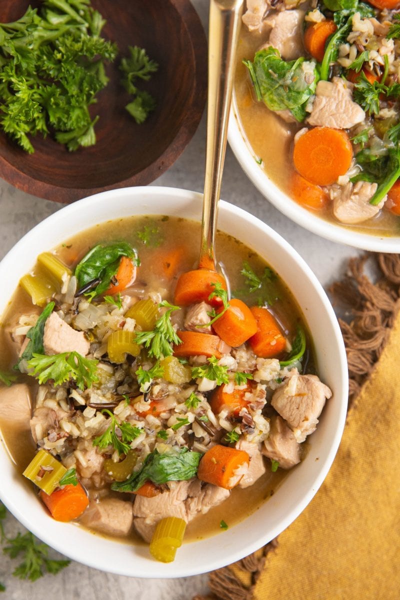 Top down image of two bowls of wild rice chicken soup.