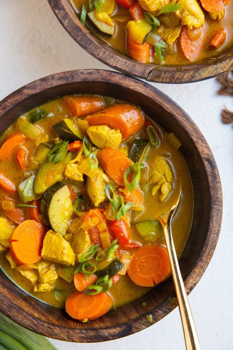 two wooden bowls of curry soup.