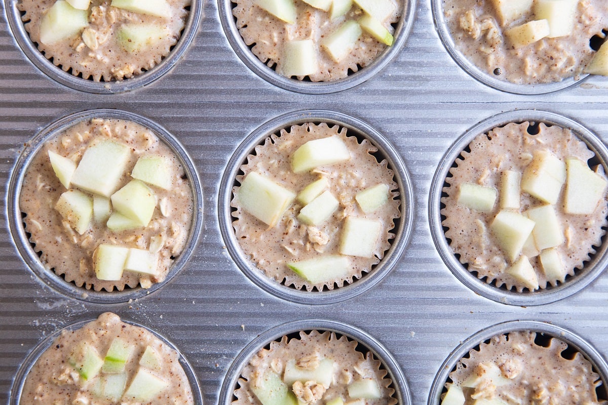 Muffin tray filled with apple oatmeal mixture.