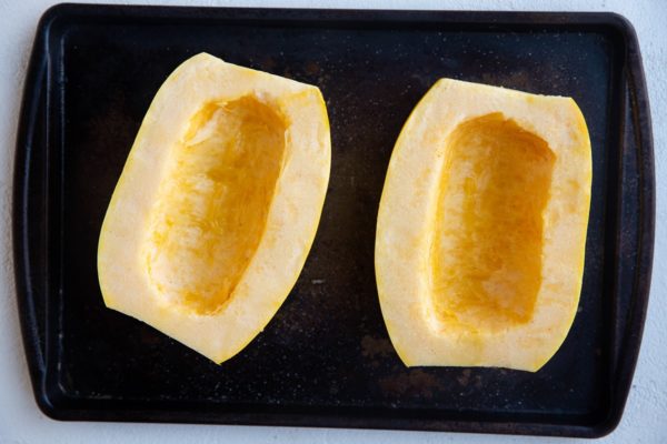 Spaghetti squash halves on a baking sheet.