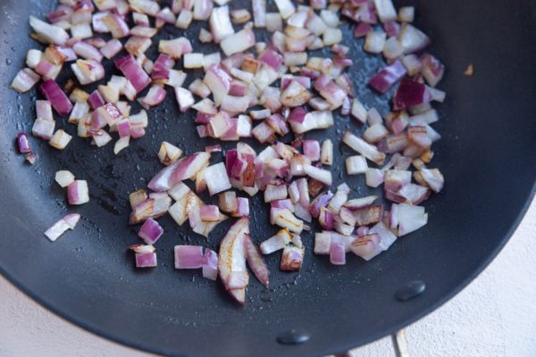 Onions sautéing in a skillet.