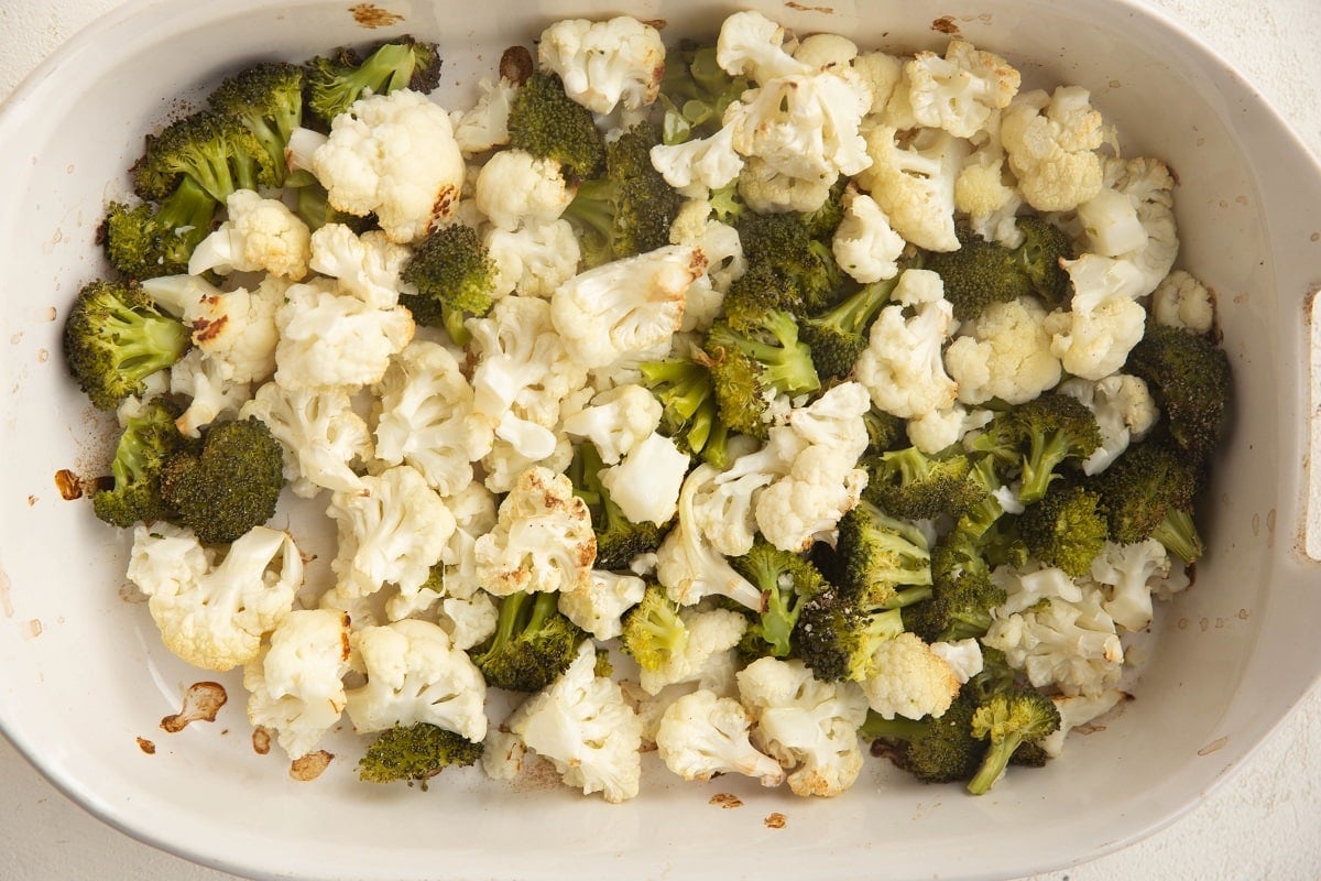 Roasted broccoli and cauliflower in a casserole dish.