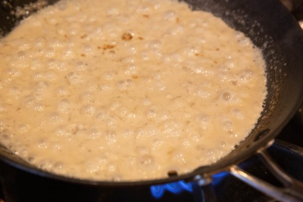 Creamy sauce cooking in a skillet.