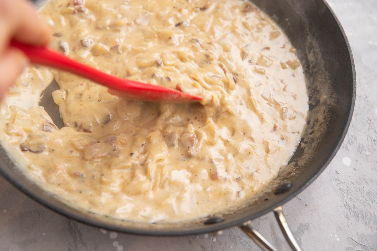 Stirring creamy sauce in a skillet