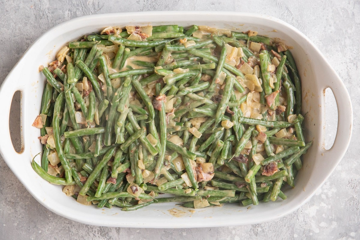 Green beans coated with creamy sauce in a casserole dish.