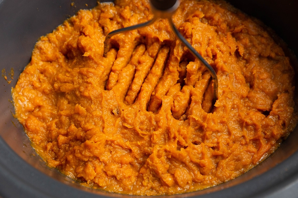 Mashed sweet potatoes inside of a slow cooker.