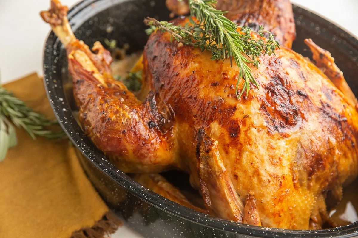 horizontal photo of Garlic Butter turkey in a roasting pan.