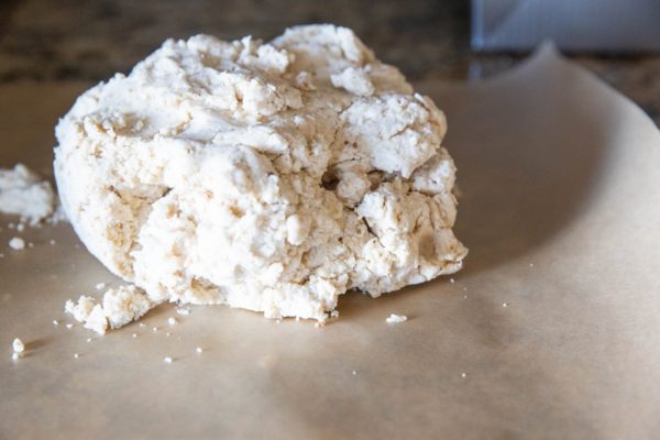 Cinnamon roll dough on a sheet of parchment paper.