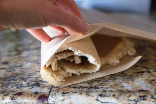 Cinnamon roll dough being rolled into a log.