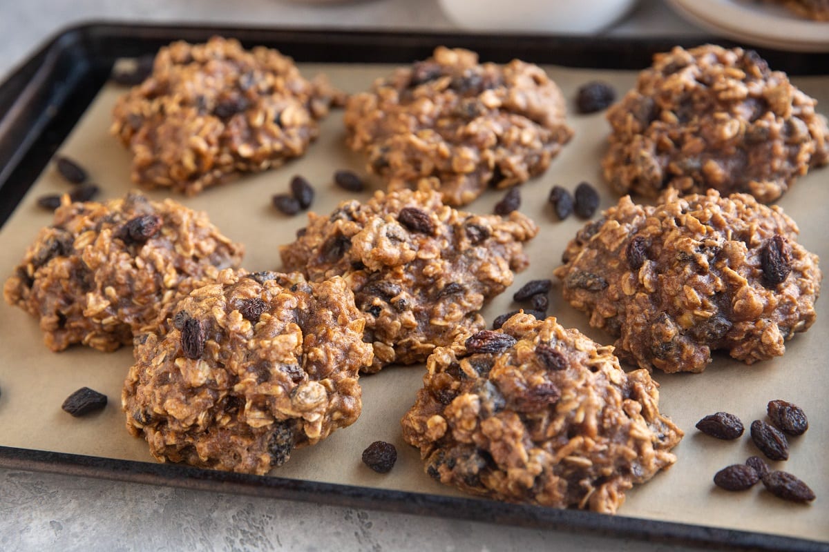 Horizontal photo of oatmeal raisin cookies on a baking sheet.