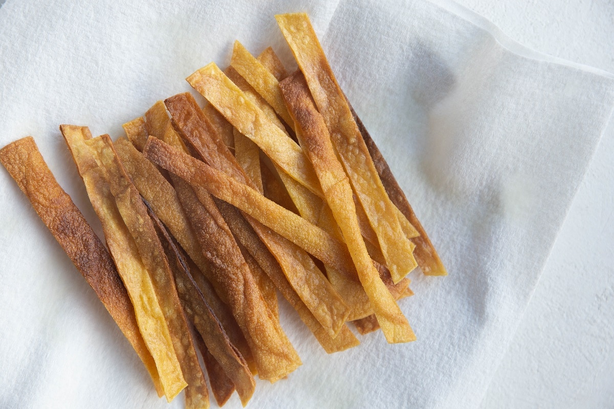 Fried corn tortilla strips on a paper towel.