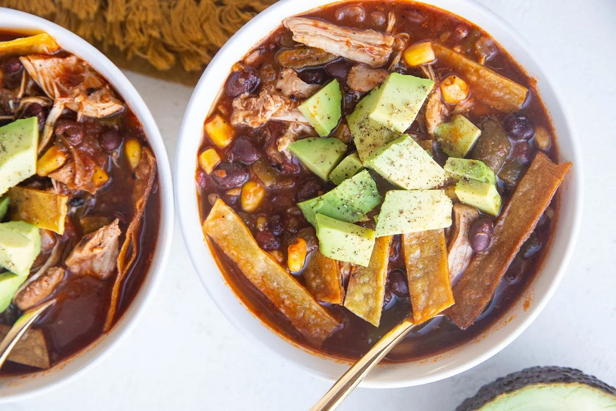Horizontal image of two bowls of chicken tortilla soup