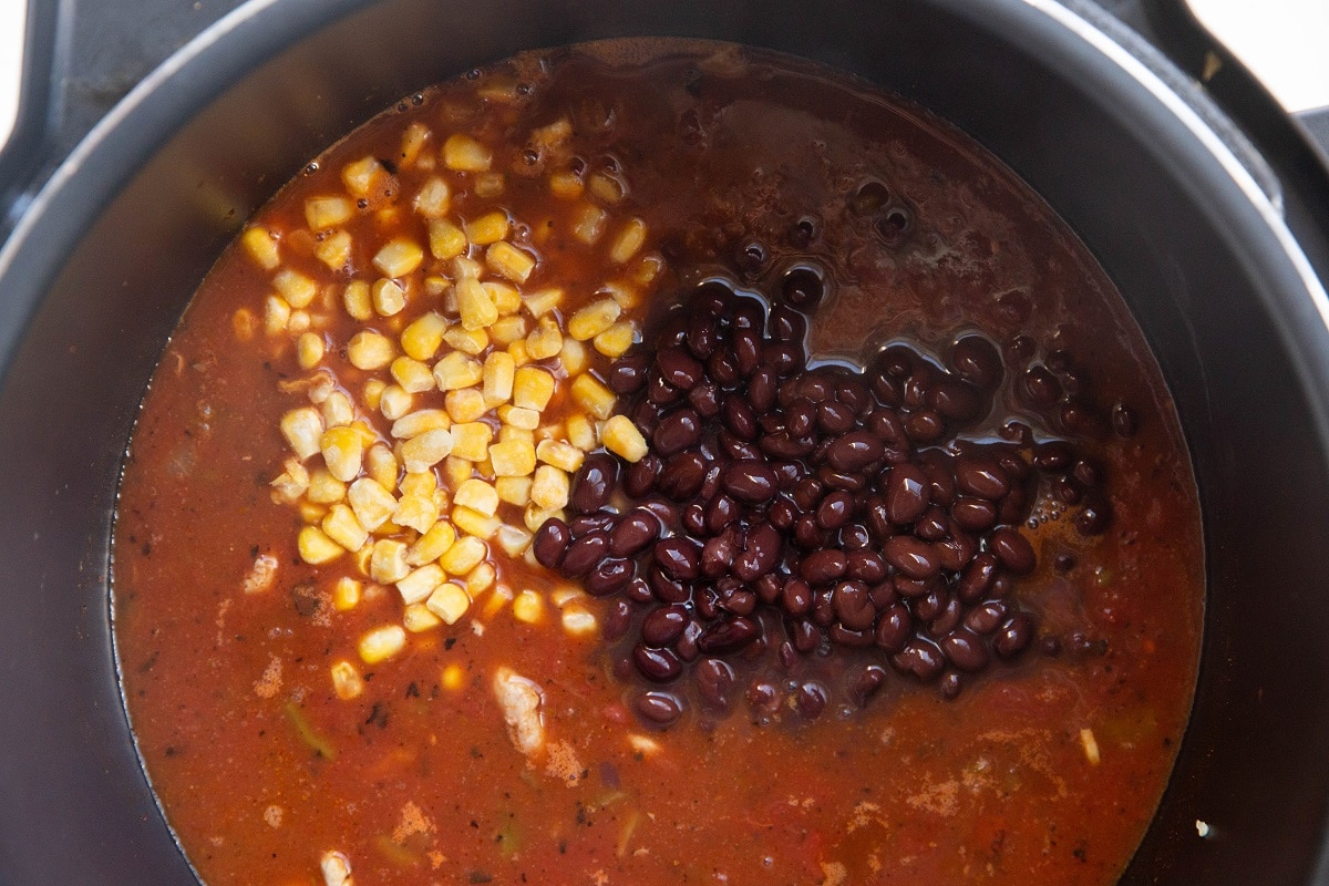 All of the ingredients for chicken tortilla soup in an Instant pot, ready to be cooked.