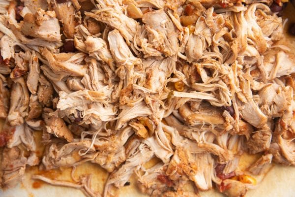 Shredded chicken on a cutting board.