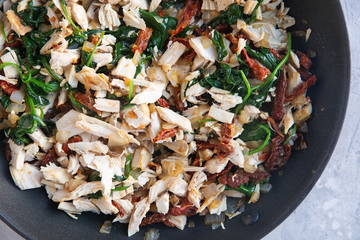 Spinach, onion, sun-dried tomatoes and chopped up leftover turkey in a skillet.