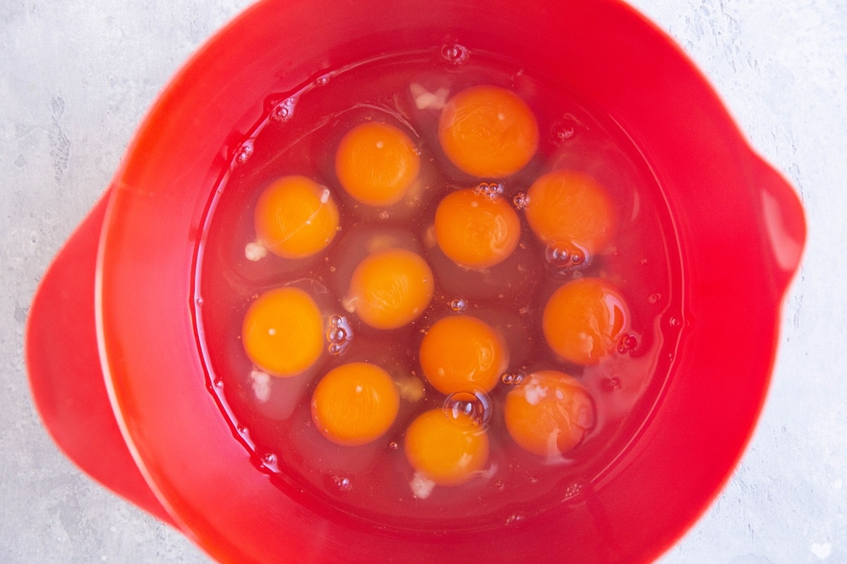 12 eggs in a mixing bowl, ready to be beaten for egg casserole.