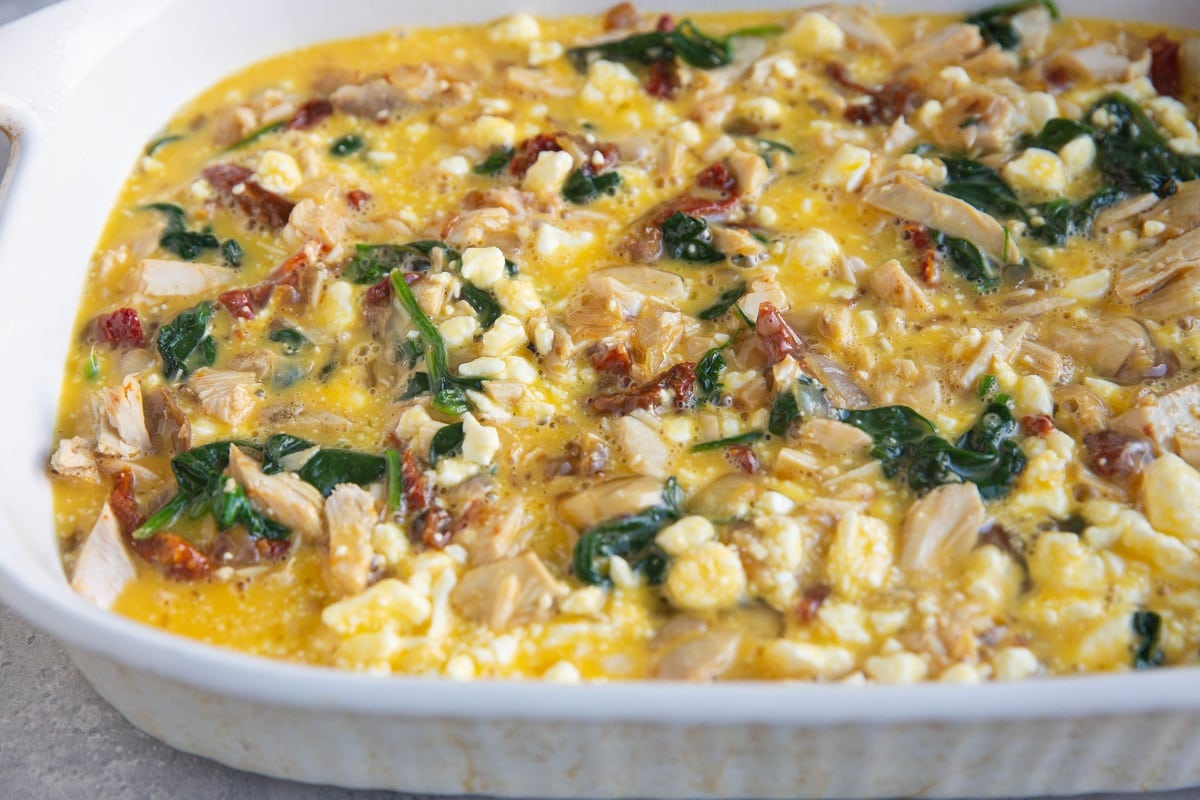 All of the ingredients for the leftover turkey breakfast casserole in a casserole dish, ready to go into the oven.