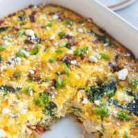 Casserole dish of leftover turkey breakfast casserole with one piece taken out and a plate with a slice of breakfast casserole in the background.