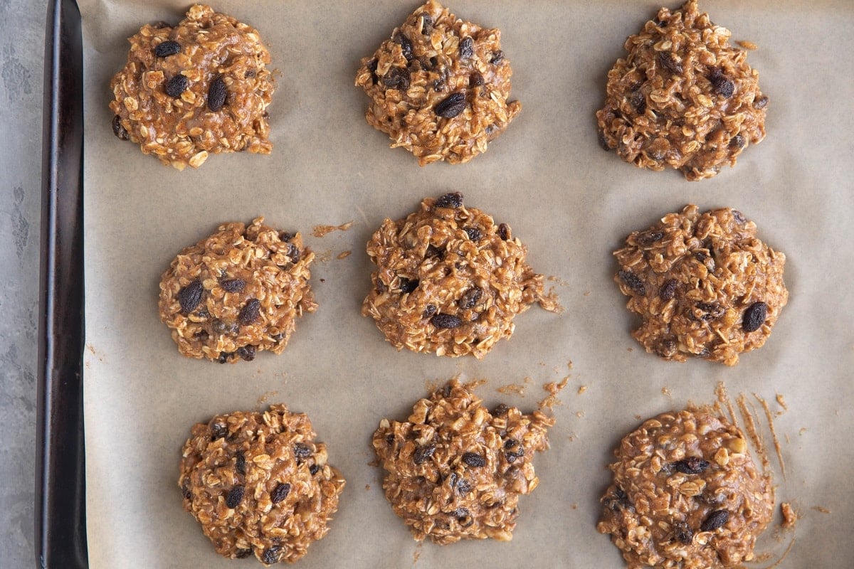 Mounds of oatmeal cookie dough on a baking sheet.