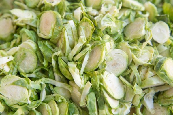 Thinly sliced brussel sprouts on a cutting board.
