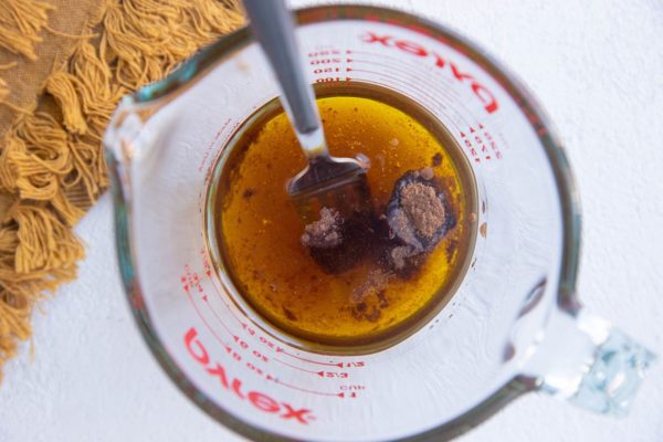 Ingredients for maple cinnamon dressing in a measuring cup.