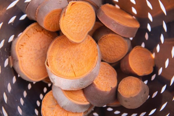 cooked sweet potatoes in a colander, ready to be put into sweet potato pie