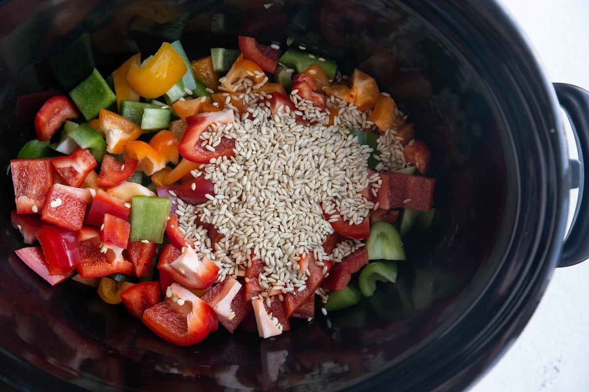 Peppers and rice in a slow cooker for soup.