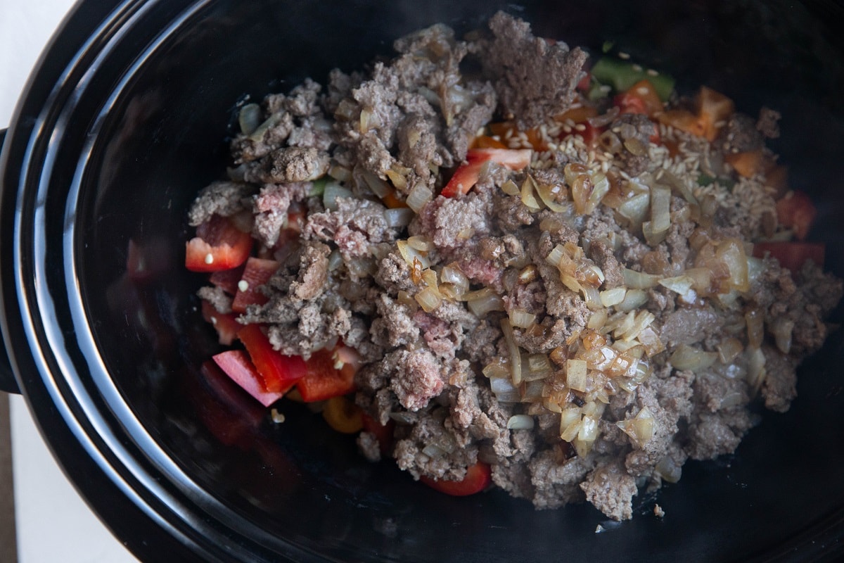 Ground beef, sauteed onion, and peppers in a crock pot.