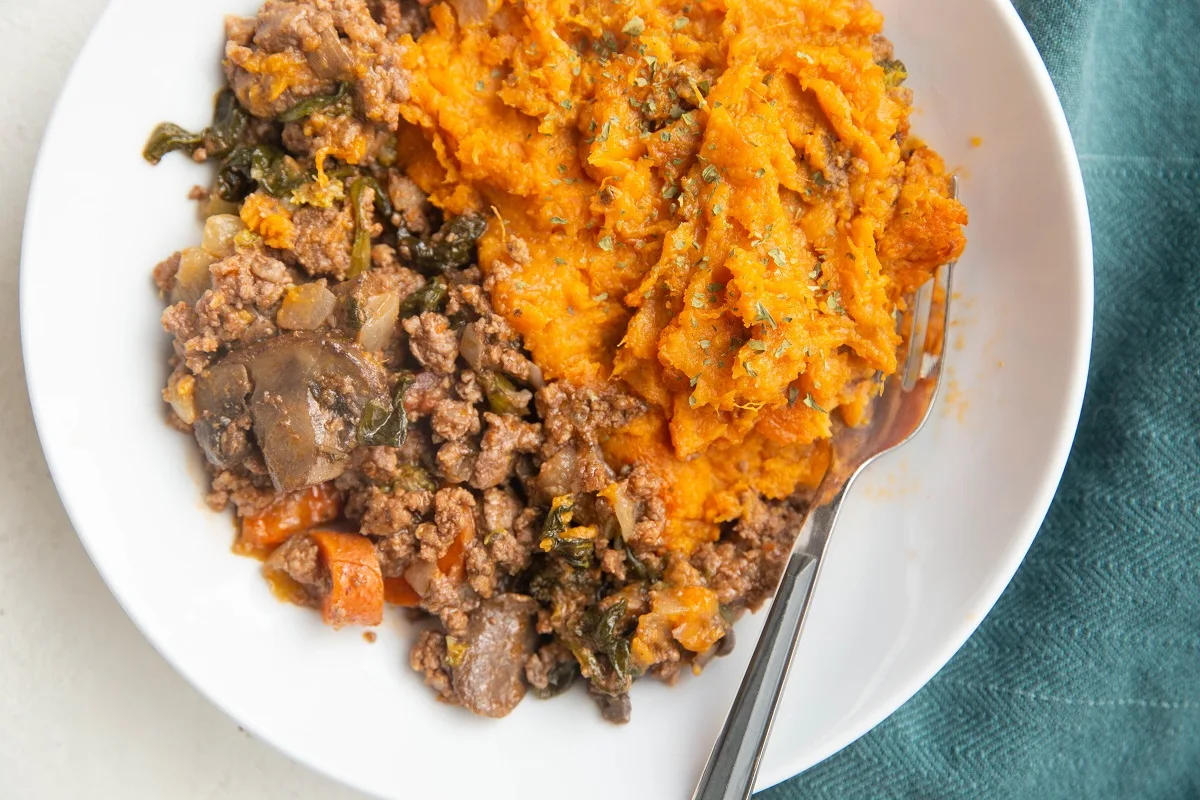 Horizontal photo of sweet potatoes and meat in a bowl.