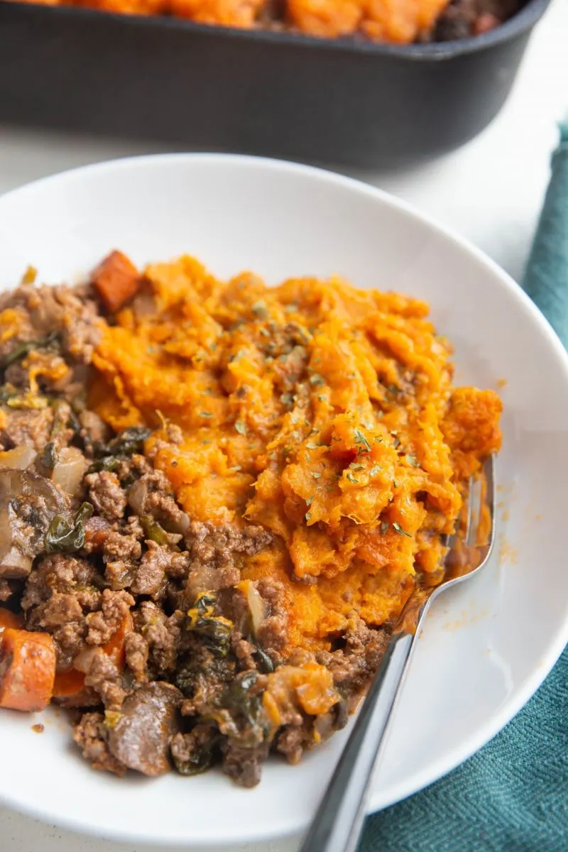 Bowl of mashed sweet potatoes and ground meat with vegetables