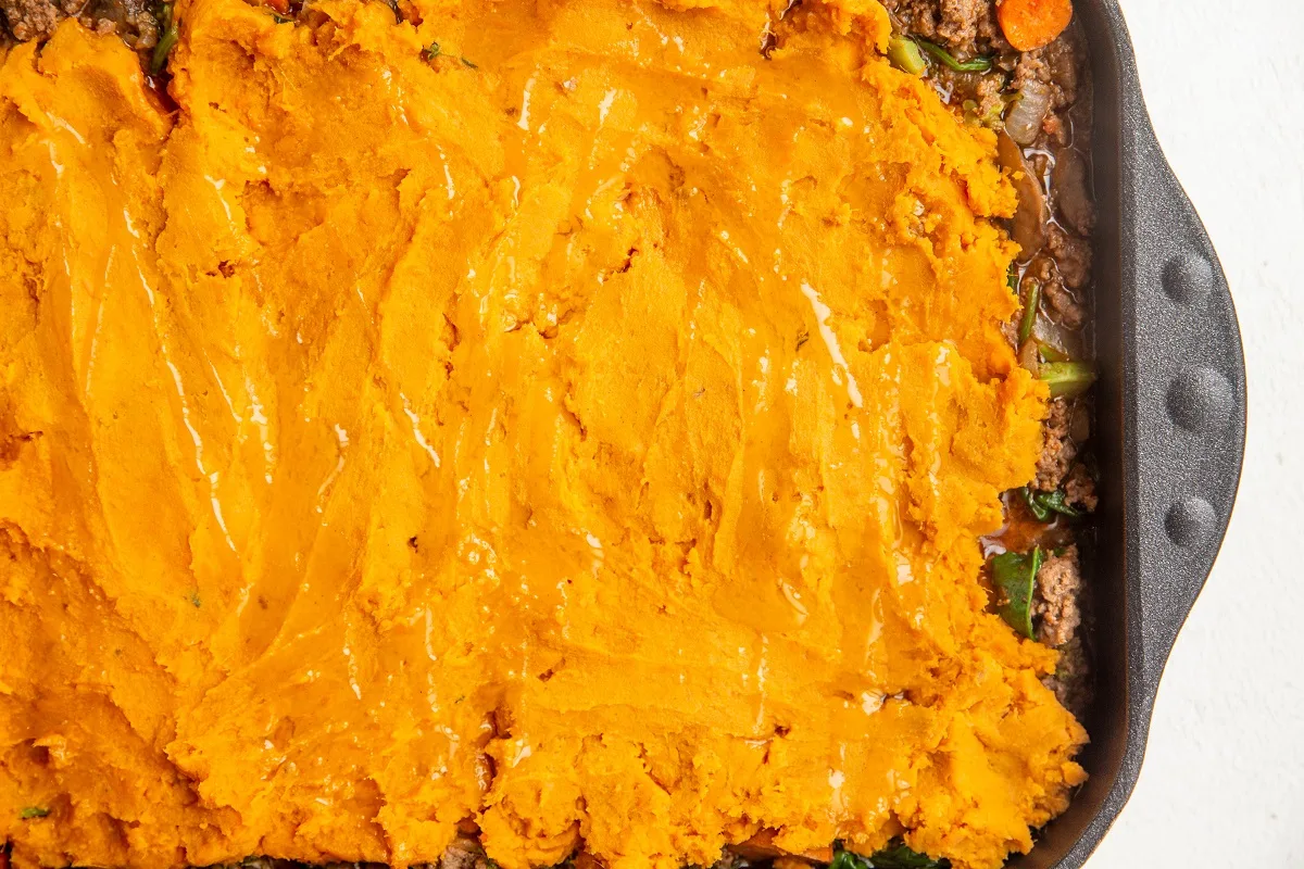 Sweet potato mash on top of meat mixture, ready to go into the oven.