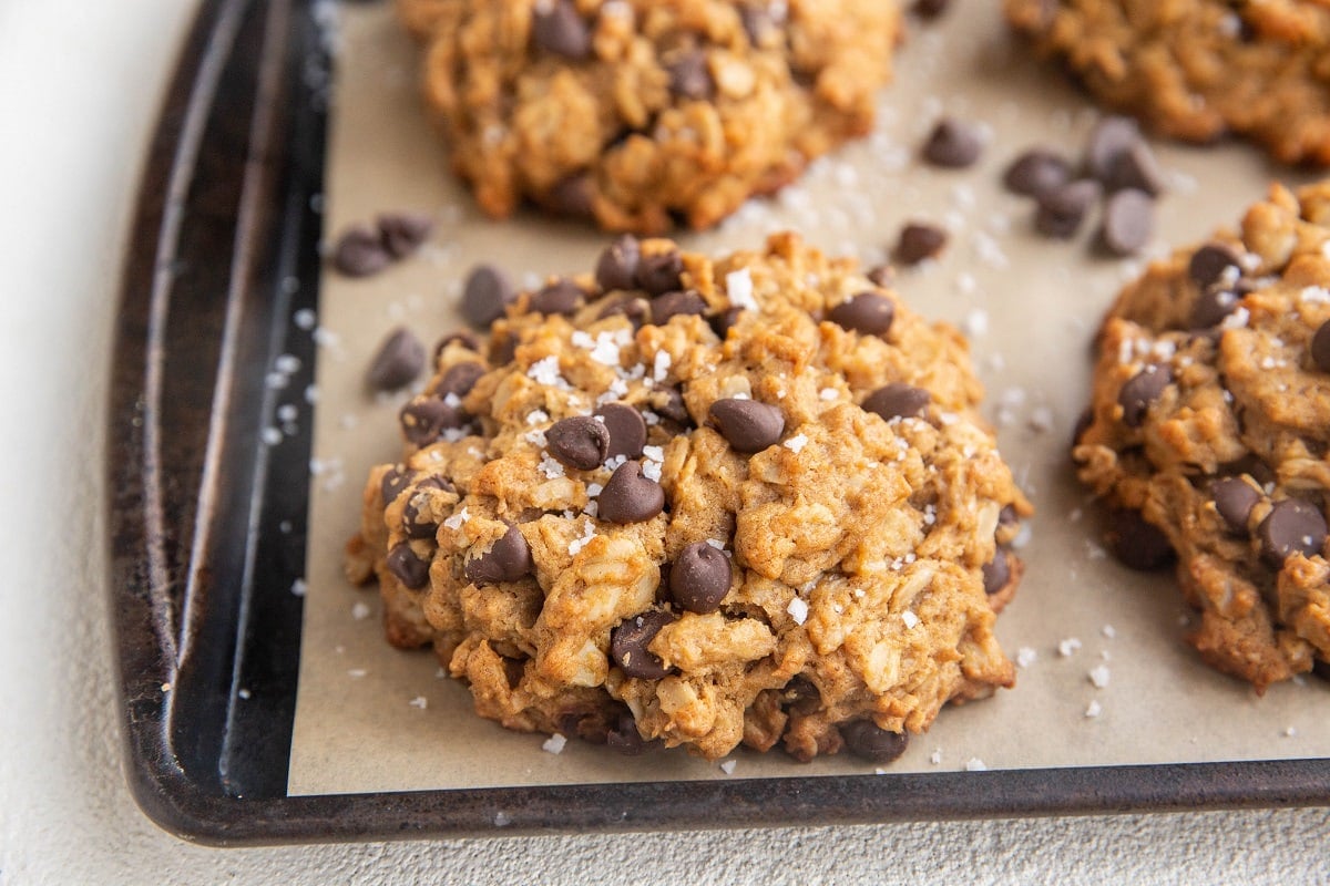 Horizontal image of peanut butter oatmeal cookies fresh out of the oven on a cookie sheet.