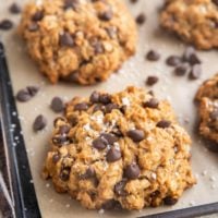 Angled photo of peanut butter oatmeal cookies on a baking sheet.