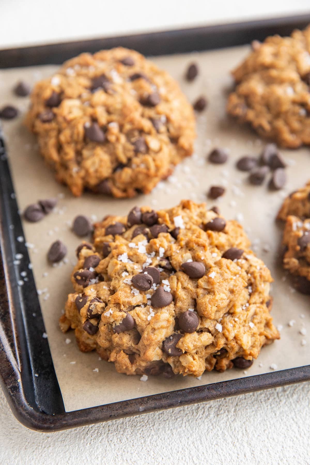 Angled photo of peanut butter oatmeal cookies on a baking sheet.